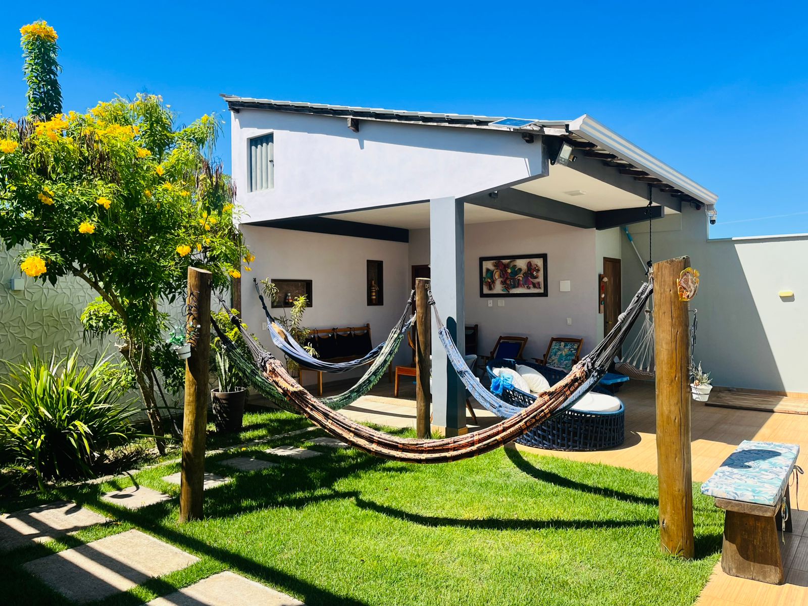 Área externa com redes, jardim e fachada da casa